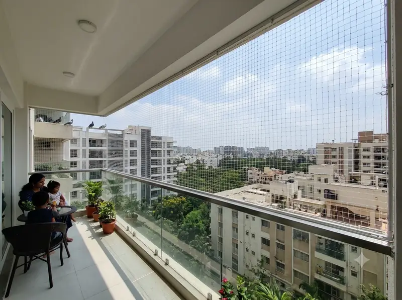 Family relaxing on a balcony protected by invisible grill cables